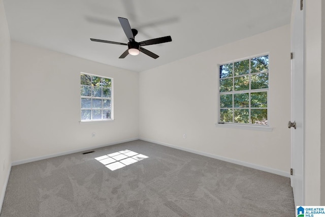 carpeted spare room featuring ceiling fan