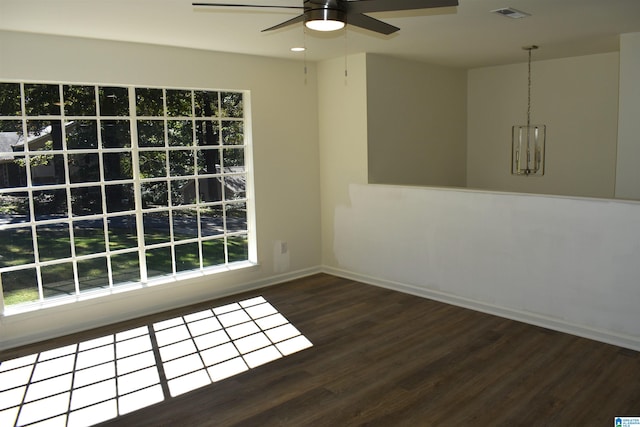 empty room featuring ceiling fan, dark hardwood / wood-style flooring, and plenty of natural light