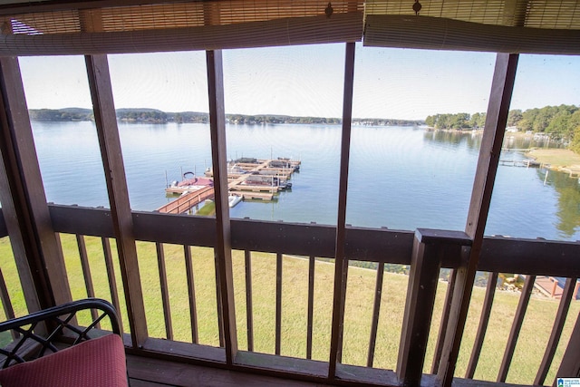 view of dock featuring a lawn and a water view