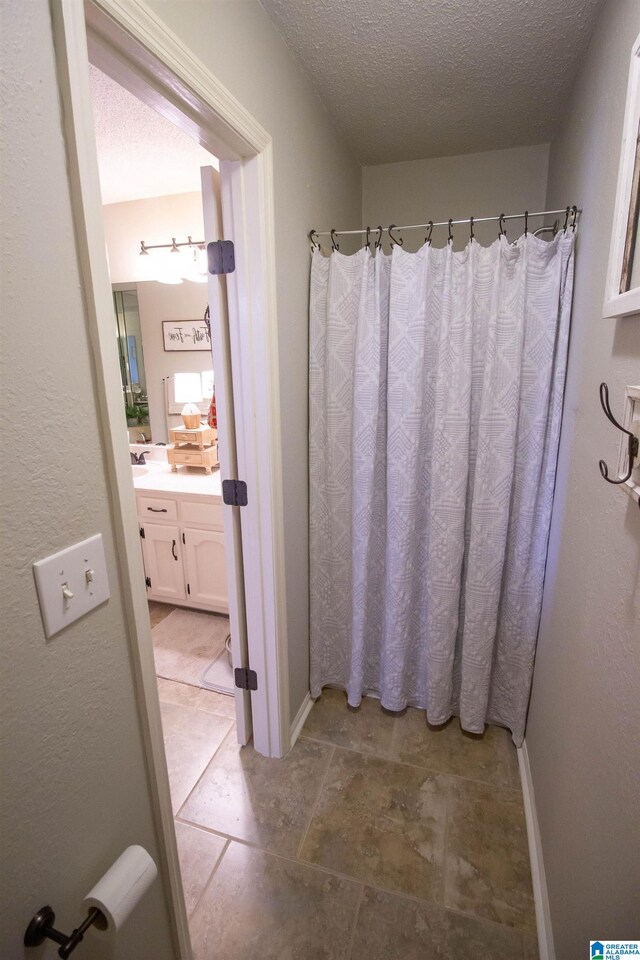 bathroom featuring vanity, a shower with curtain, and a textured ceiling