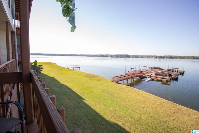 dock area with a water view and a lawn