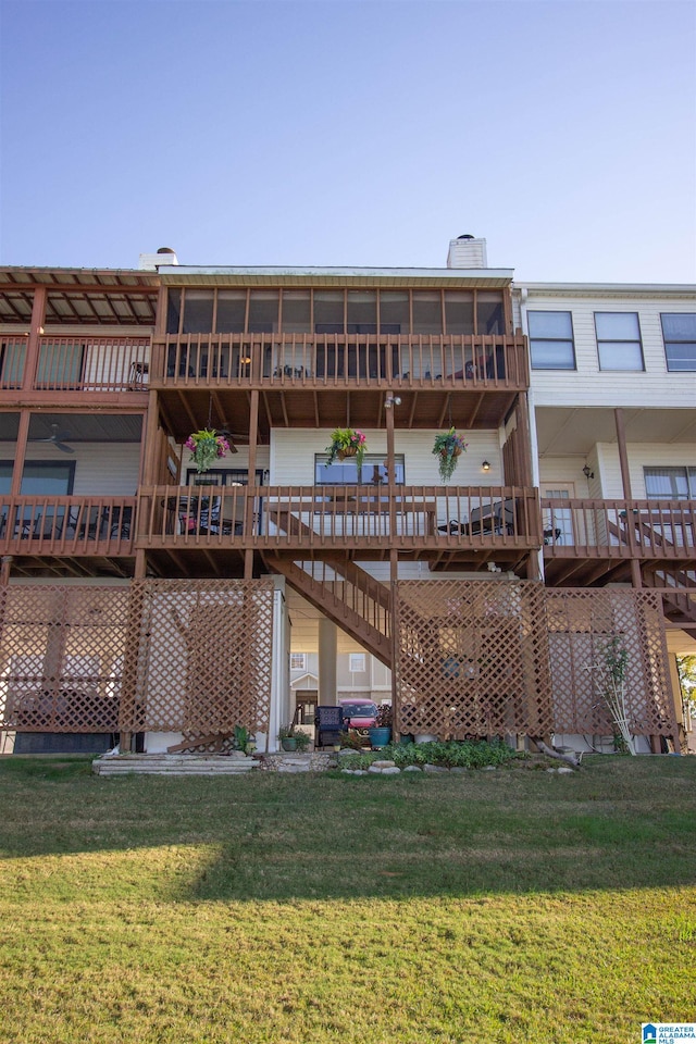 back of house featuring a deck and a lawn