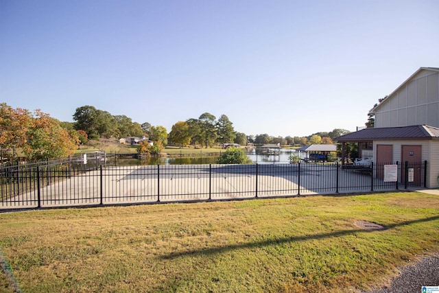 view of swimming pool featuring a water view and a yard