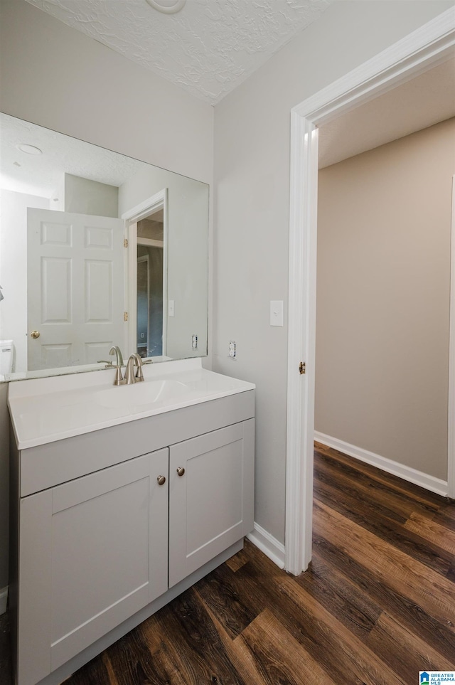 bathroom with vanity, a textured ceiling, and wood-type flooring