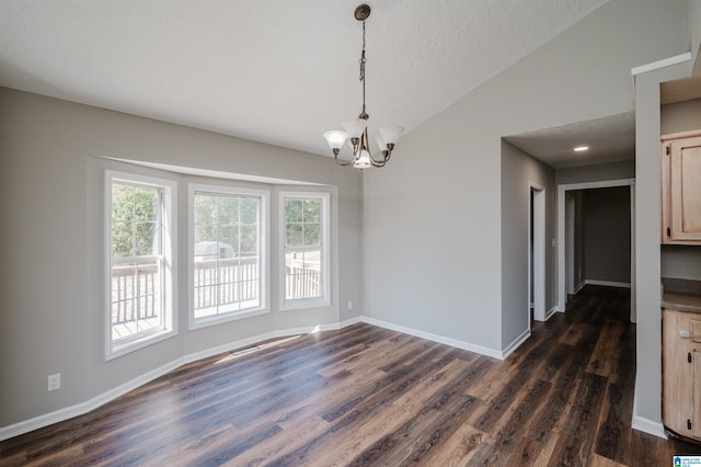 unfurnished dining area featuring a textured ceiling, vaulted ceiling, dark hardwood / wood-style floors, and an inviting chandelier