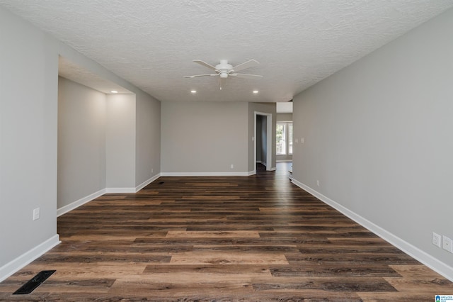 spare room with a textured ceiling, ceiling fan, and dark hardwood / wood-style flooring