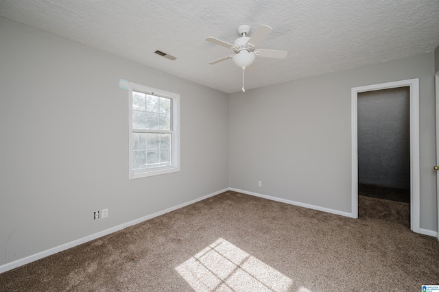 empty room with ceiling fan, a textured ceiling, and carpet floors