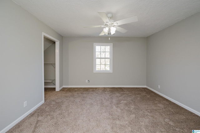 spare room featuring a textured ceiling, light colored carpet, and ceiling fan