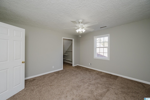 carpeted empty room featuring a textured ceiling and ceiling fan