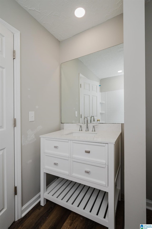 bathroom featuring vanity, a textured ceiling, and hardwood / wood-style flooring