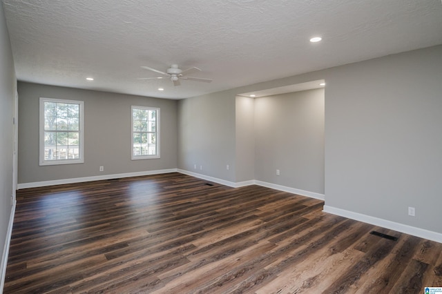 unfurnished room with a textured ceiling, dark wood-type flooring, and ceiling fan