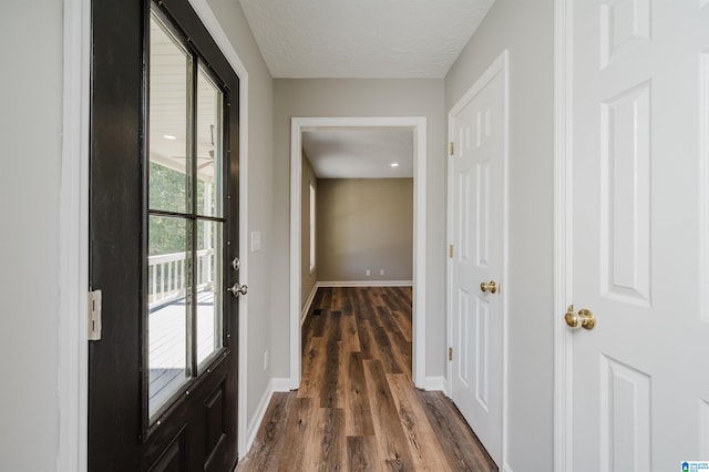 entryway with a textured ceiling and dark wood-type flooring