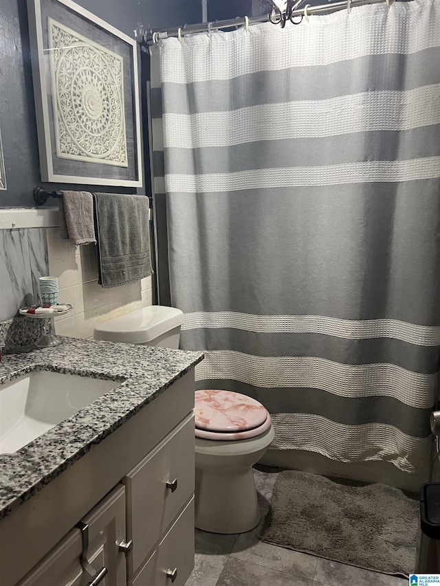 bathroom with toilet, vanity, and curtained shower