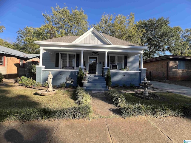 bungalow with covered porch, brick siding, a ceiling fan, fence, and board and batten siding