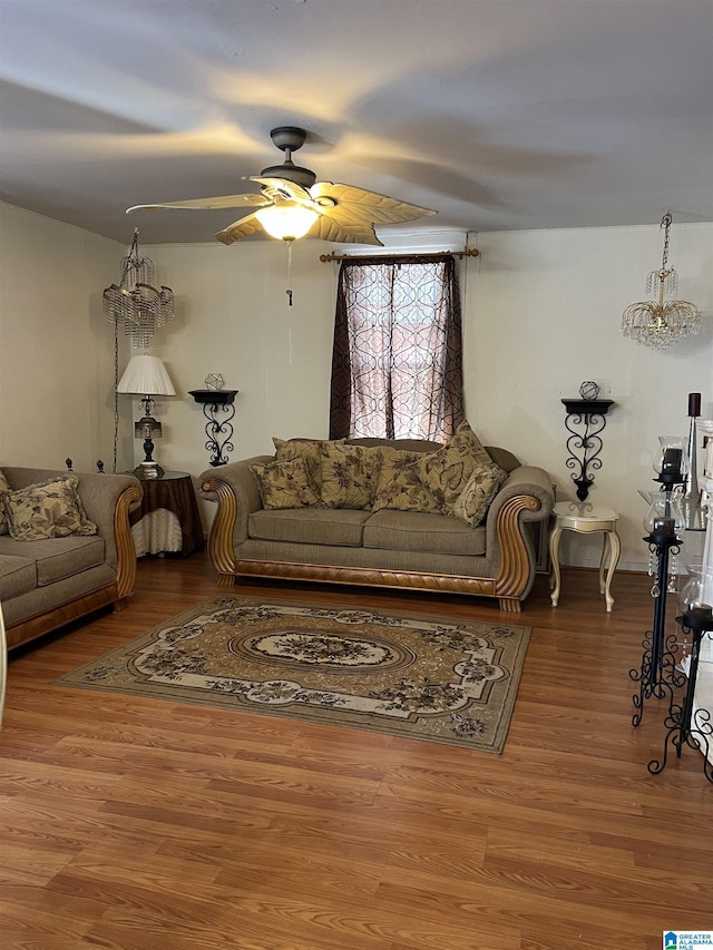 living area featuring a ceiling fan, wood finished floors, and a chandelier
