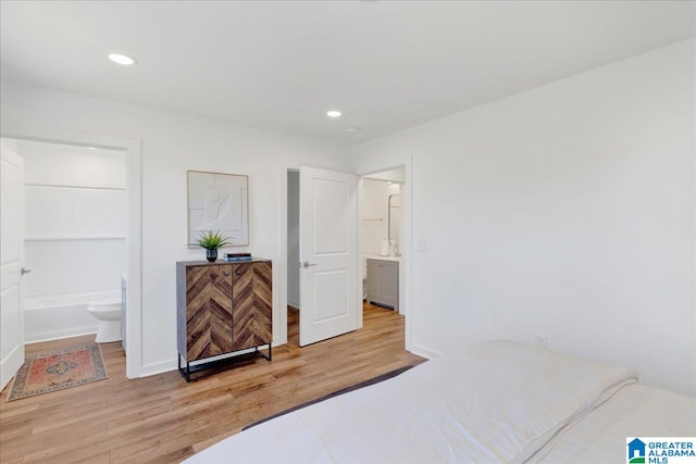 bedroom featuring ensuite bath and light wood-type flooring