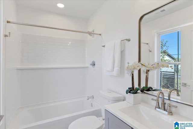 full bathroom with tiled shower / bath, vanity, toilet, and plenty of natural light