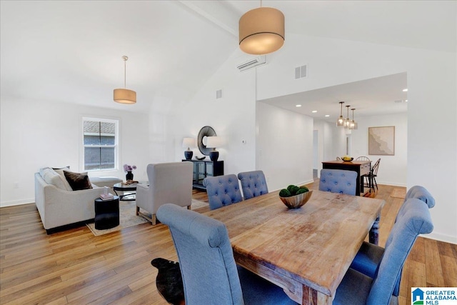 dining space with a notable chandelier, light hardwood / wood-style floors, and high vaulted ceiling