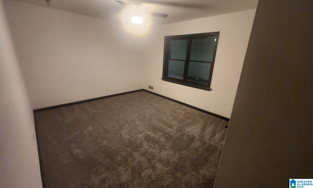 unfurnished room featuring dark colored carpet and ceiling fan