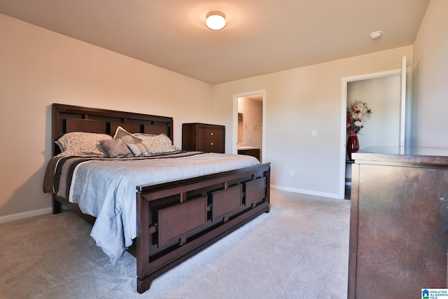 bedroom featuring light carpet and ensuite bath