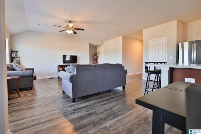 living room with dark wood-type flooring, ceiling fan, and vaulted ceiling