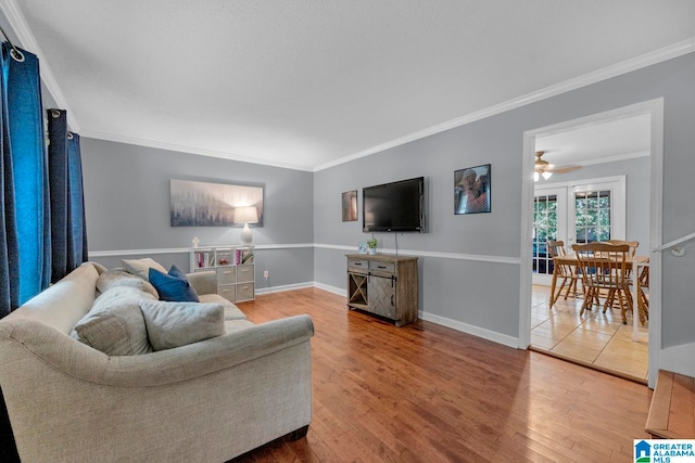 living room featuring ceiling fan, ornamental molding, and hardwood / wood-style floors