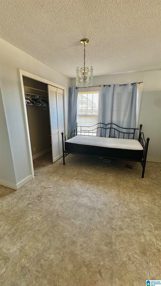 unfurnished bedroom with a closet, a textured ceiling, and an inviting chandelier