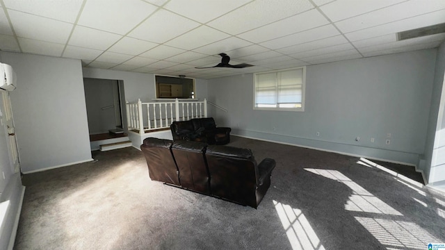 carpeted living room featuring a paneled ceiling, an AC wall unit, and ceiling fan