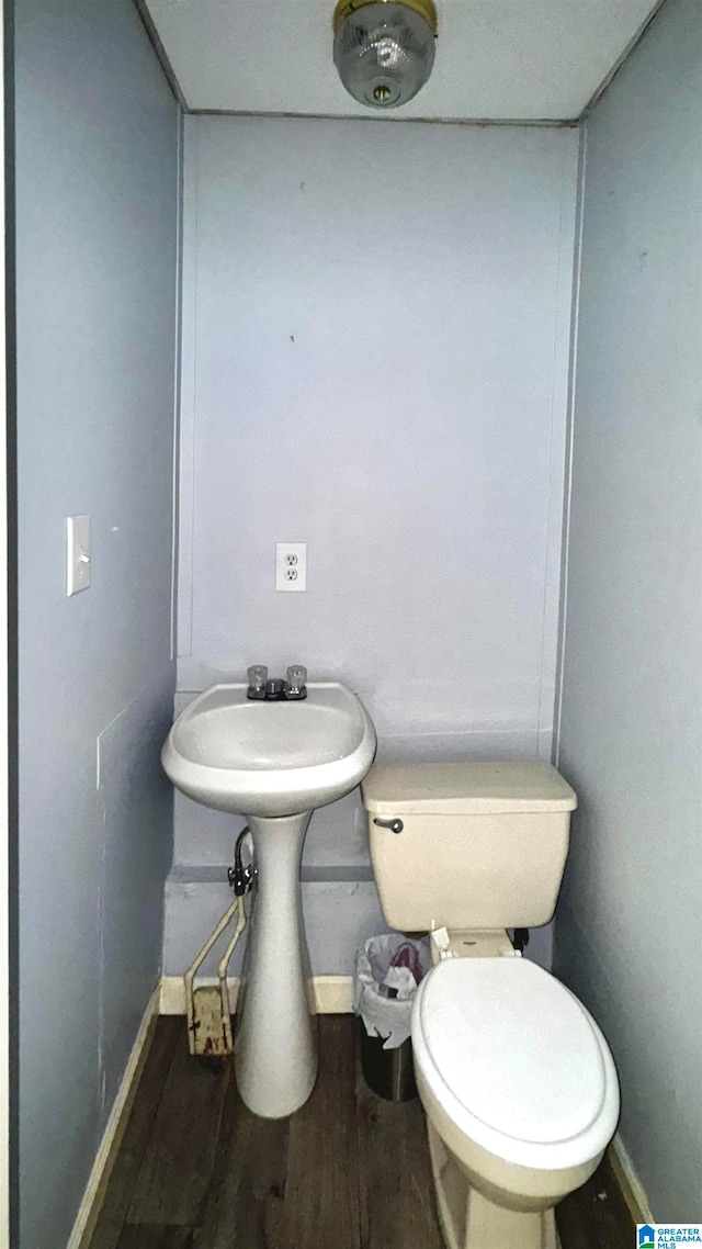 bathroom with toilet and wood-type flooring