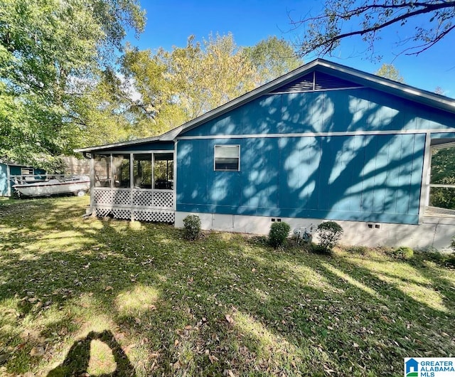 view of side of property featuring a lawn and a sunroom