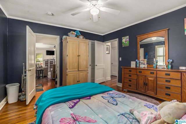 bedroom featuring dark hardwood / wood-style flooring, crown molding, and ceiling fan