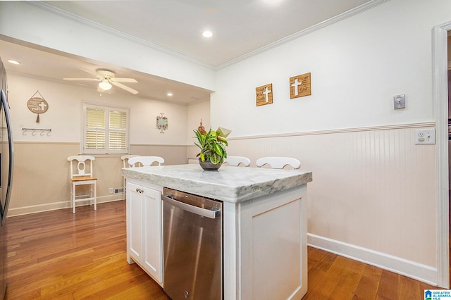 kitchen featuring a kitchen island, ornamental molding, white cabinetry, light hardwood / wood-style floors, and ceiling fan