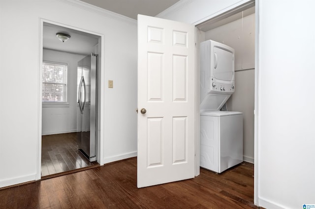 clothes washing area featuring ornamental molding, dark hardwood / wood-style floors, and stacked washer / dryer