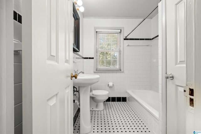 bathroom with tiled shower / bath, tile walls, ornamental molding, and toilet