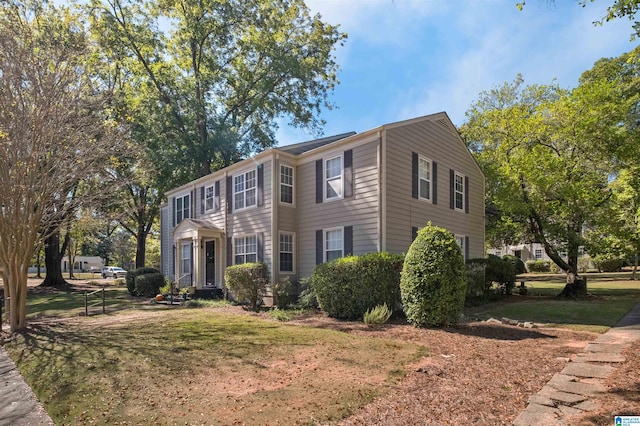 colonial-style house featuring a front yard