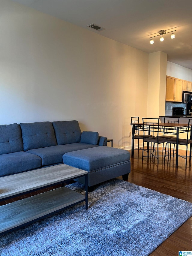 living room with track lighting and dark hardwood / wood-style flooring