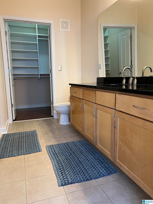 bathroom with vanity, toilet, and tile patterned flooring