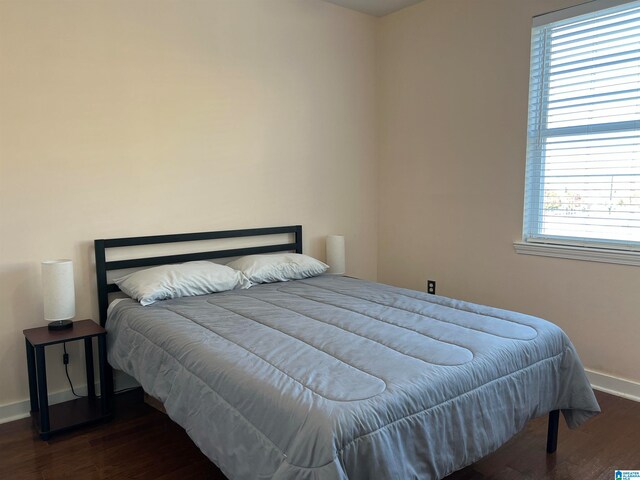 bedroom with dark wood-type flooring