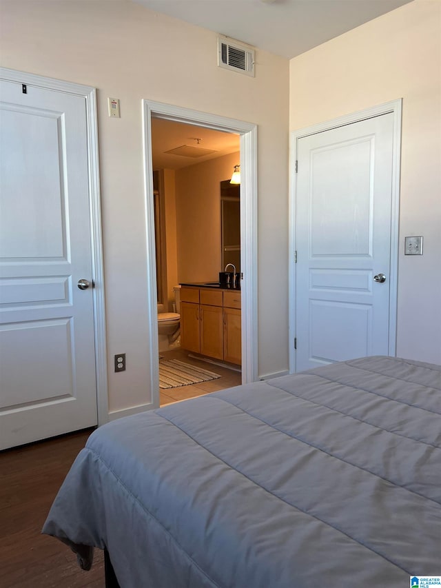 bedroom featuring a closet, hardwood / wood-style floors, and ensuite bathroom