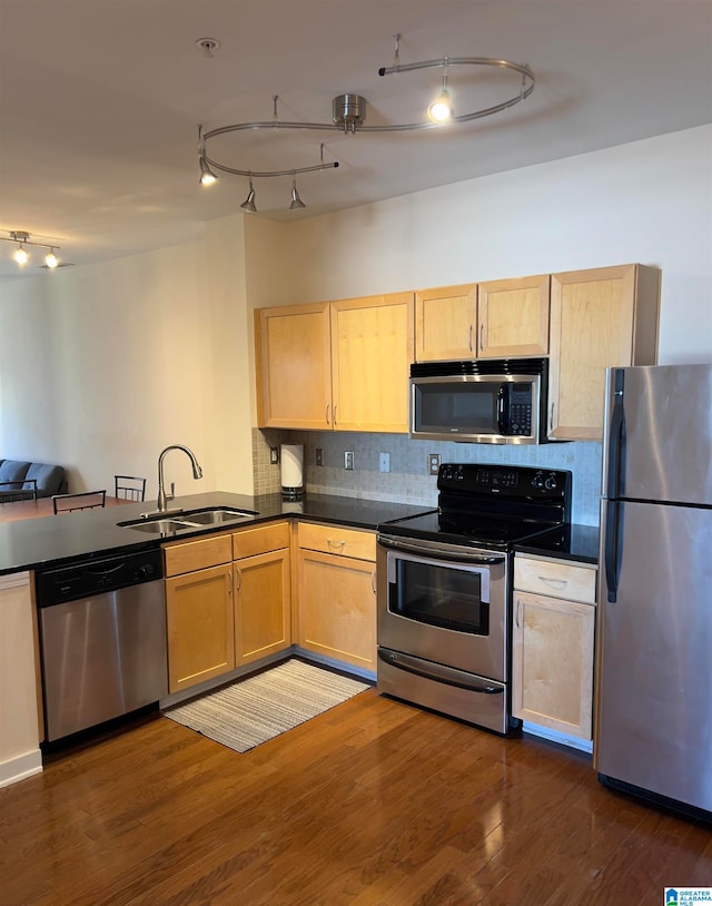 kitchen featuring light brown cabinets, dark wood-type flooring, stainless steel appliances, sink, and tasteful backsplash