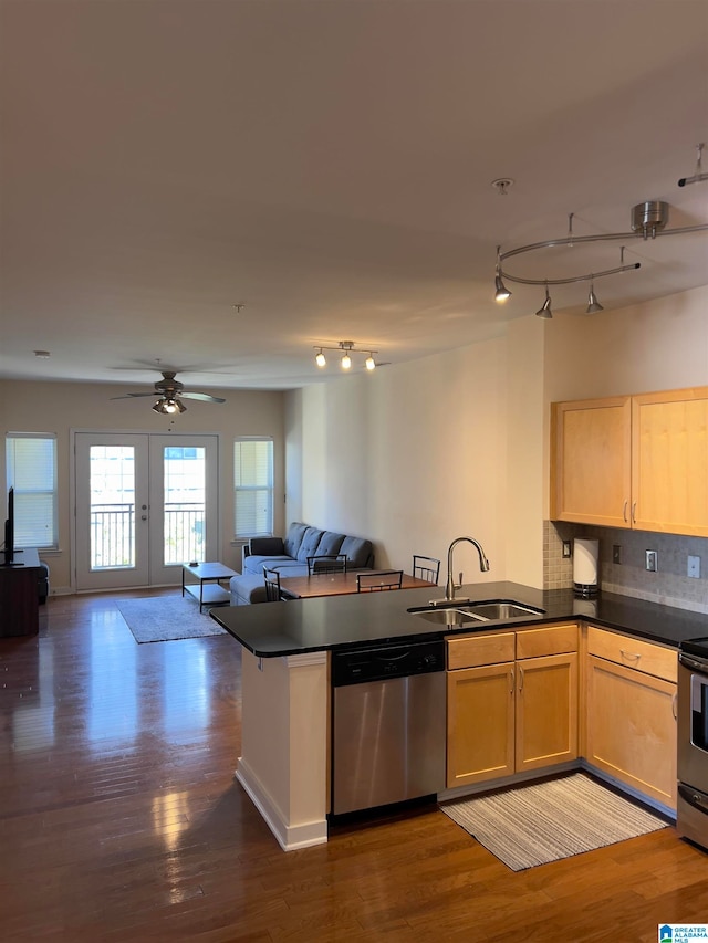 kitchen with kitchen peninsula, tasteful backsplash, dark hardwood / wood-style flooring, appliances with stainless steel finishes, and sink