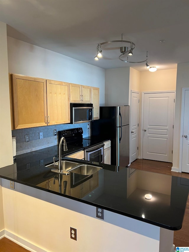 kitchen with backsplash, appliances with stainless steel finishes, kitchen peninsula, and dark hardwood / wood-style floors