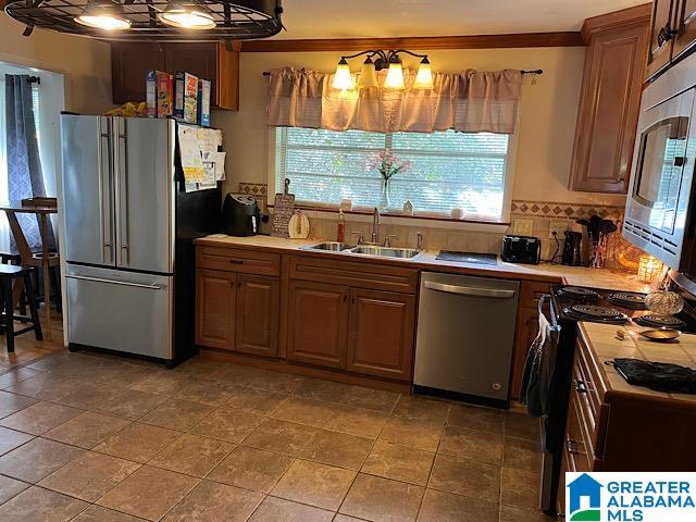 kitchen featuring appliances with stainless steel finishes, sink, decorative backsplash, and ornamental molding