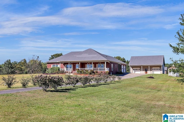 ranch-style house featuring covered porch, a garage, an outdoor structure, and a front yard