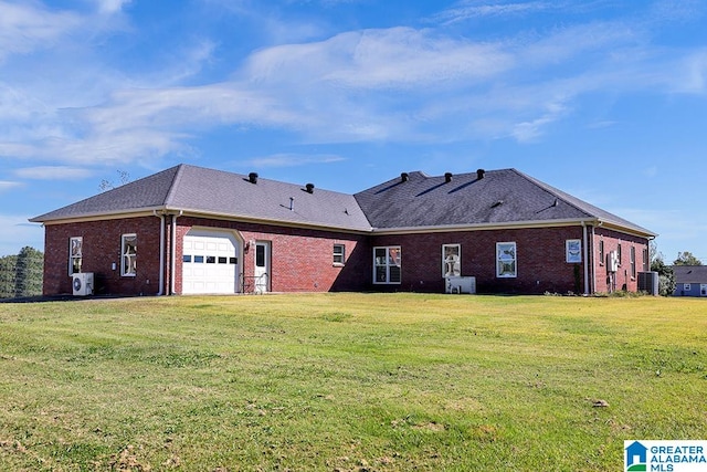 rear view of property with central air condition unit, a lawn, and a garage