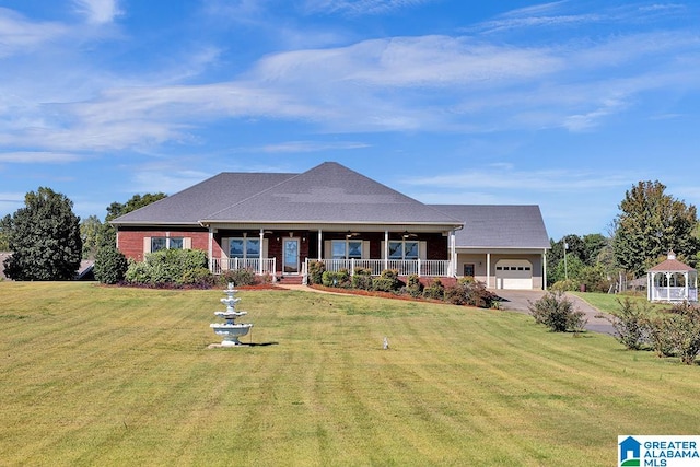 view of front of home with covered porch, a garage, and a front yard