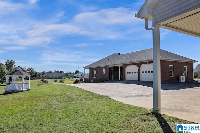 view of side of home featuring a gazebo, a garage, and a lawn