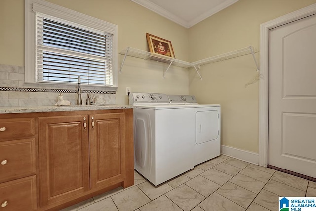 laundry area with cabinets, ornamental molding, washer and clothes dryer, sink, and light tile patterned floors