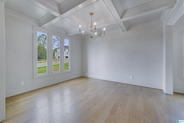 spare room featuring baseboards, beamed ceiling, light wood finished floors, an inviting chandelier, and coffered ceiling