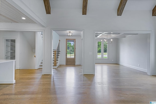 entryway with light wood-type flooring, stairs, a chandelier, and beamed ceiling